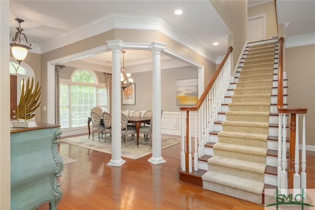 interior space with ornamental molding, a notable chandelier, and hardwood / wood-style flooring