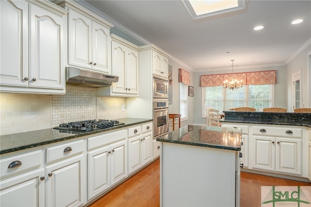 kitchen featuring a center island, light hardwood / wood-style floors, a notable chandelier, and appliances with stainless steel finishes