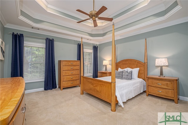 bedroom with ceiling fan, crown molding, light carpet, and a tray ceiling