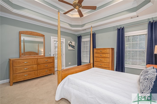 bedroom with ceiling fan, light colored carpet, crown molding, and a tray ceiling