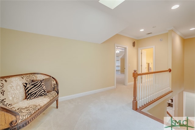 living area with a skylight, light colored carpet, and ornamental molding