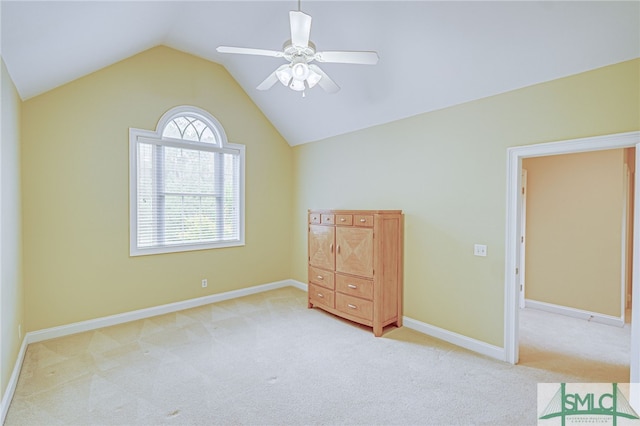 unfurnished bedroom with multiple windows, ceiling fan, light colored carpet, and vaulted ceiling