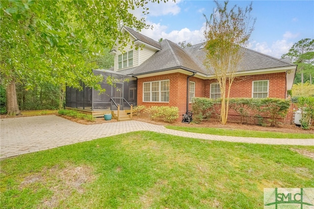 view of front of home with a sunroom and a front lawn