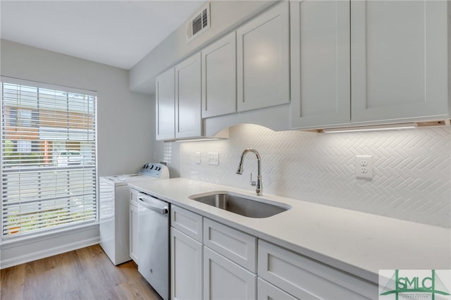 kitchen with a wealth of natural light, dishwasher, white cabinetry, and sink