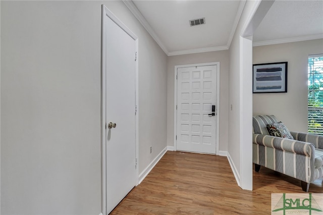 entryway with light wood-type flooring and crown molding