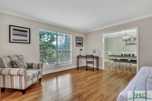 sitting room featuring an inviting chandelier, hardwood / wood-style flooring, ornamental molding, and a textured ceiling