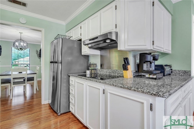 kitchen featuring stainless steel fridge, white cabinetry, crown molding, an inviting chandelier, and light hardwood / wood-style flooring