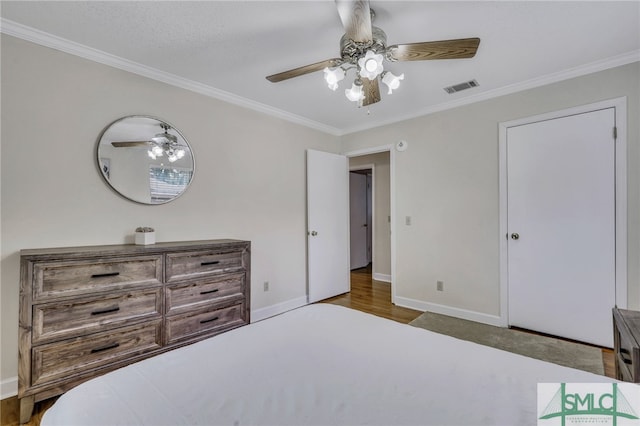 bedroom featuring ornamental molding, dark wood-type flooring, and ceiling fan