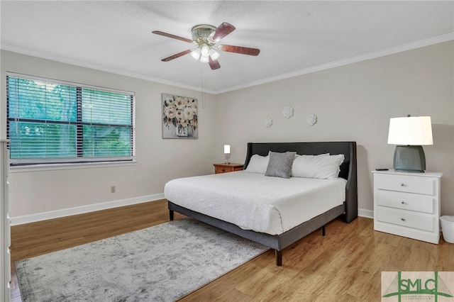 bedroom featuring ceiling fan, light hardwood / wood-style flooring, and crown molding