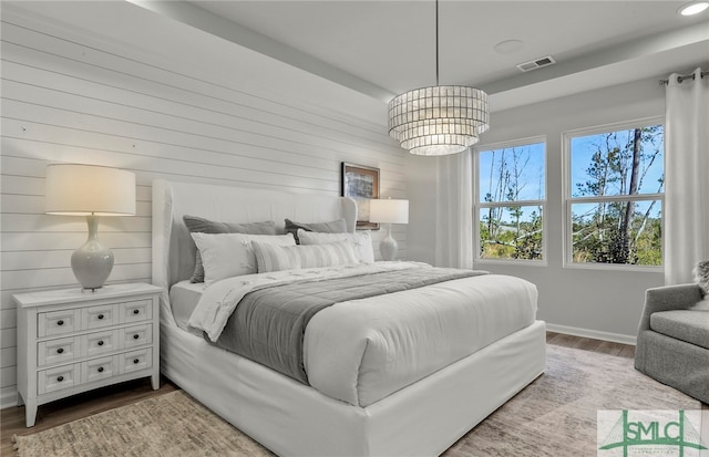 bedroom featuring wood-type flooring and a notable chandelier