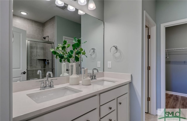 bathroom featuring wood-type flooring, vanity, and a shower with door