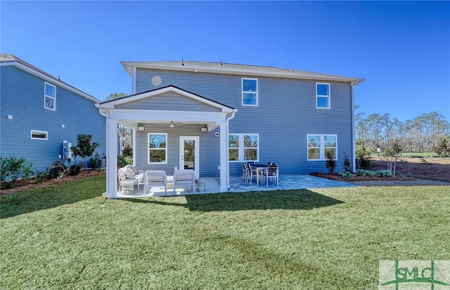 back of house featuring ceiling fan, outdoor lounge area, a lawn, and a patio