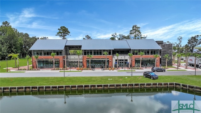 exterior space featuring a lawn and a water view