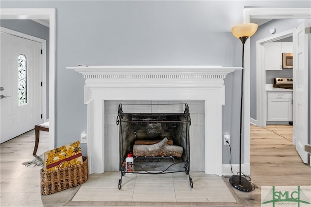 interior details with hardwood / wood-style floors and a tile fireplace