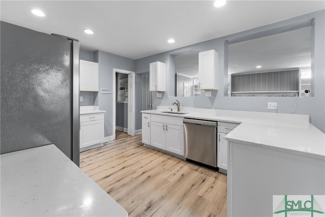 kitchen featuring sink, stainless steel dishwasher, white cabinetry, refrigerator, and light hardwood / wood-style floors