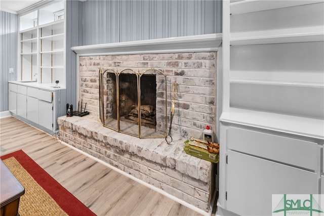 living room featuring a brick fireplace and hardwood / wood-style floors