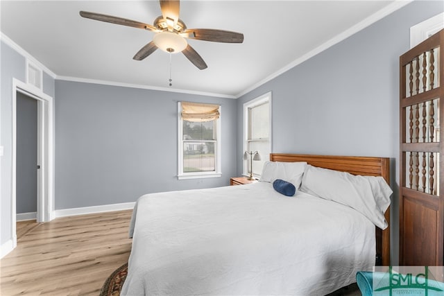 bedroom featuring ornamental molding, light wood-type flooring, and ceiling fan