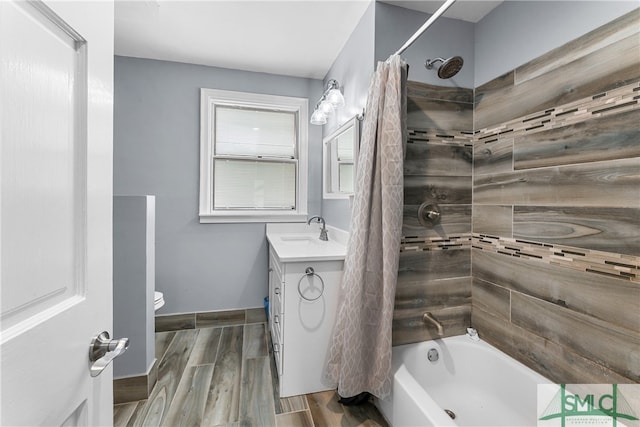 full bathroom with shower / bath combination with curtain, hardwood / wood-style floors, vanity, and toilet