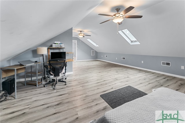 office with light hardwood / wood-style floors, lofted ceiling with skylight, and ceiling fan