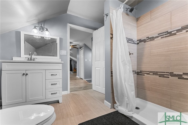 bathroom featuring vaulted ceiling, vanity, walk in shower, ceiling fan, and toilet