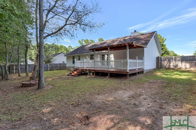 rear view of house featuring a deck and a lawn