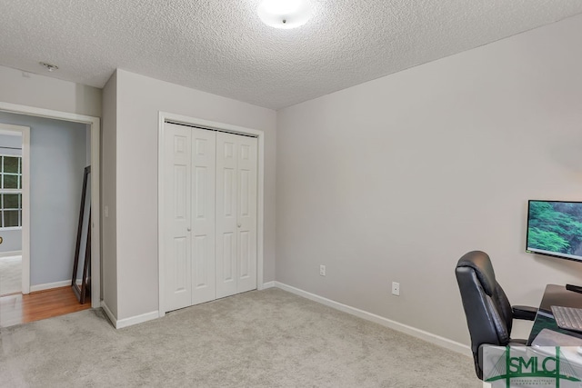 office space with light colored carpet and a textured ceiling