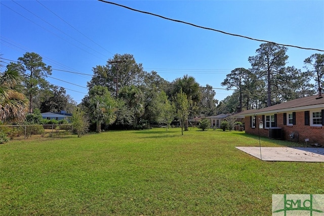 view of yard with central air condition unit and a patio