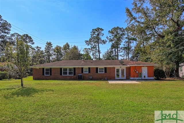 rear view of property featuring a yard, a patio, and central air condition unit