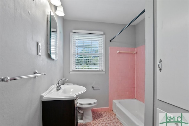 full bathroom featuring tile patterned flooring, tiled shower / bath combo, vanity, and toilet