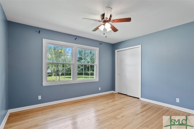 unfurnished bedroom with a closet, light hardwood / wood-style floors, and ceiling fan