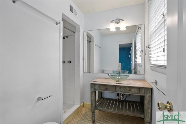 bathroom with vanity and a tile shower