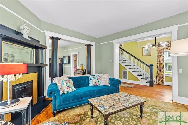 living room featuring wood-type flooring and a tiled fireplace