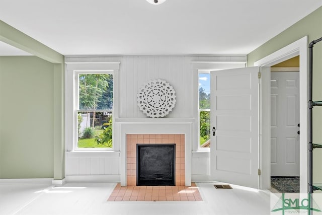 unfurnished living room featuring a tiled fireplace