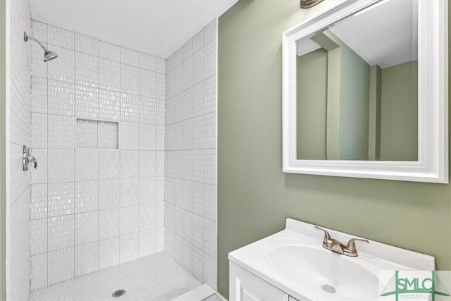 bathroom featuring a tile shower and vanity