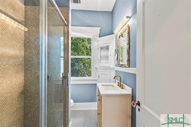 bathroom featuring a shower with shower door, vanity, and toilet