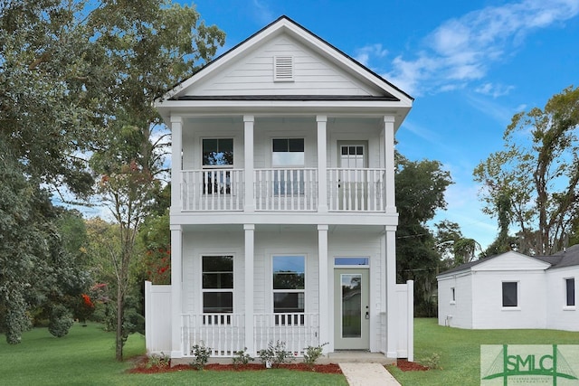 view of front facade featuring a porch, a balcony, and a front lawn