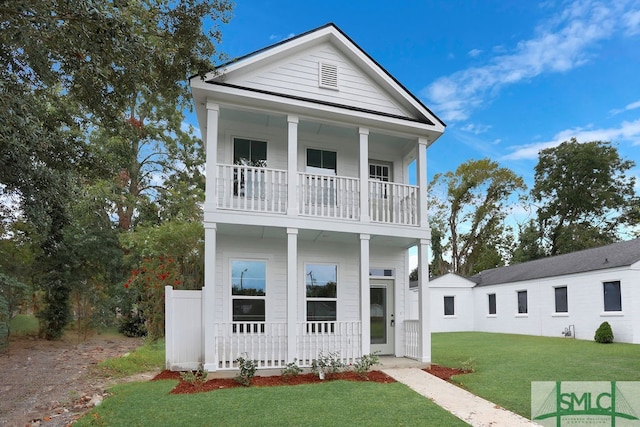 view of front facade with a front lawn, covered porch, and a balcony