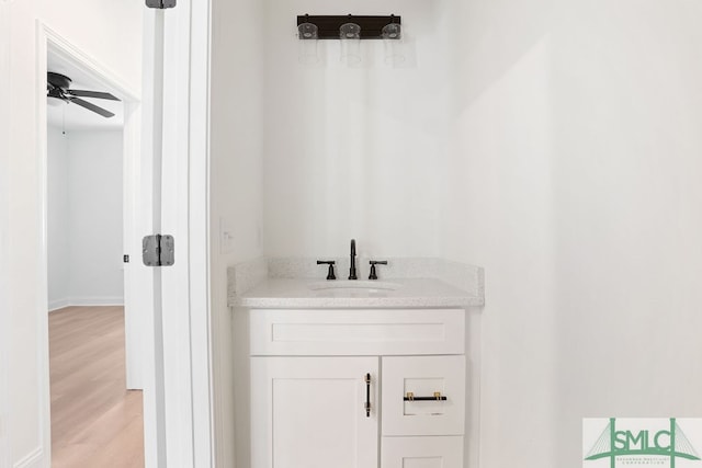 bathroom with ceiling fan, vanity, and hardwood / wood-style floors