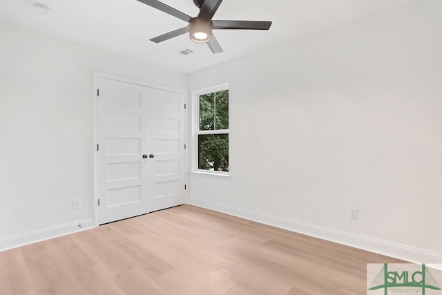 unfurnished bedroom featuring ceiling fan, light wood-type flooring, and a closet