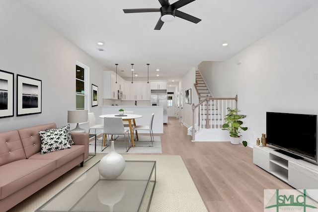 living room with ceiling fan and light hardwood / wood-style flooring