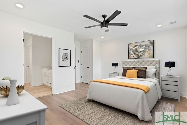 bedroom with ensuite bath, ceiling fan, and light hardwood / wood-style floors