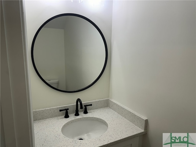 bathroom featuring vanity and toilet