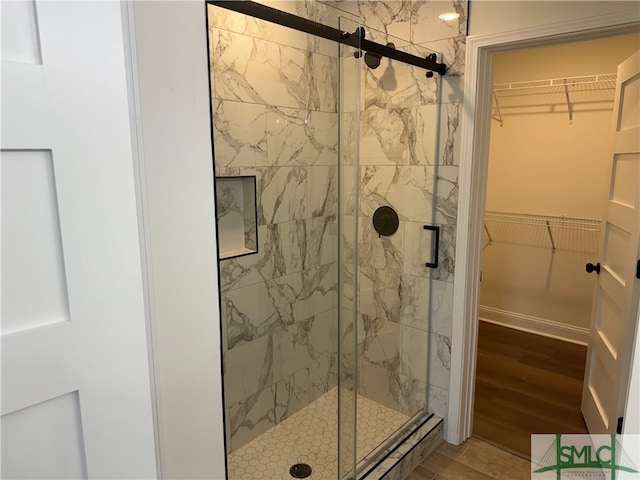 bathroom featuring hardwood / wood-style flooring and a shower with shower door