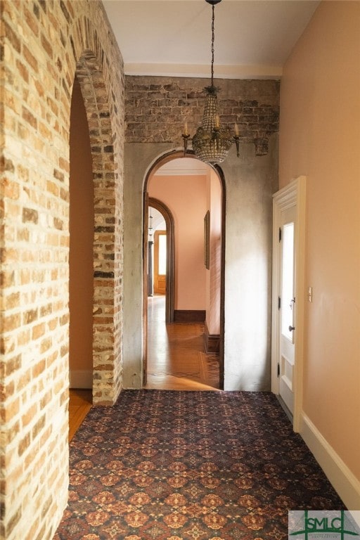 hall with wood-type flooring and a notable chandelier