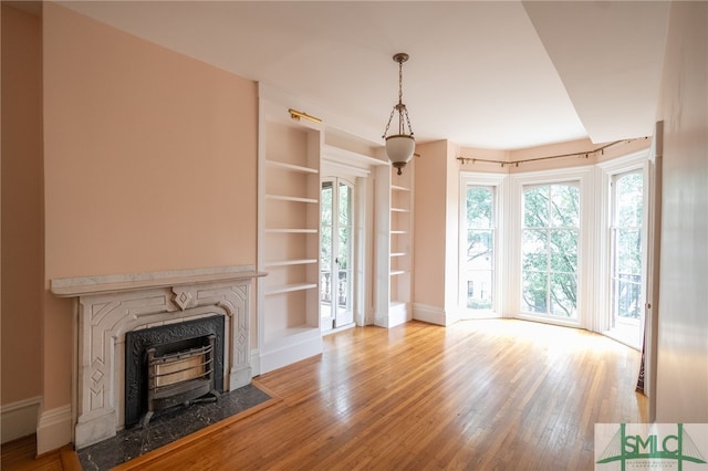 unfurnished living room with wood-type flooring and built in features