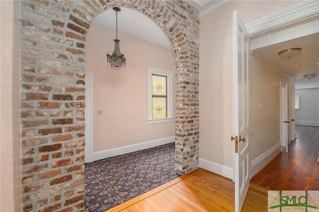 foyer entrance with crown molding and hardwood / wood-style floors