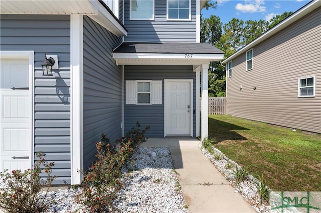 property entrance featuring a lawn