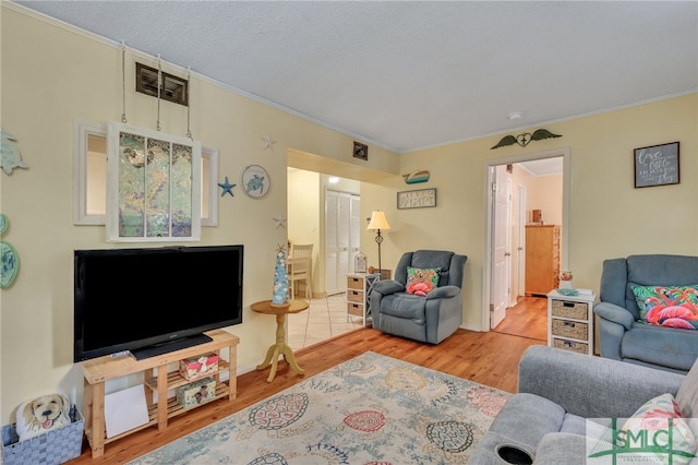 living room featuring crown molding and light hardwood / wood-style floors