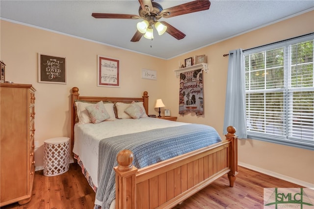 bedroom with ornamental molding, ceiling fan, and hardwood / wood-style floors