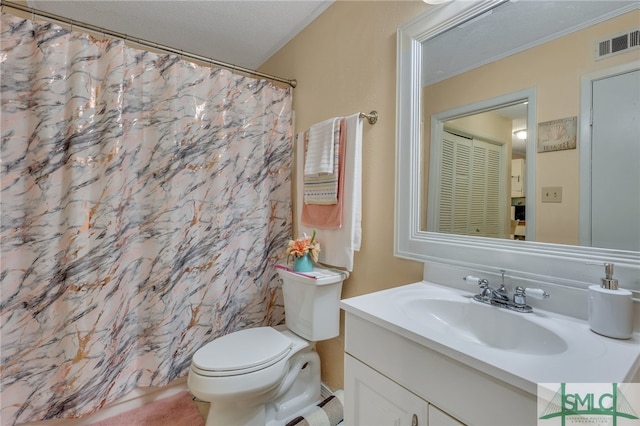 bathroom featuring walk in shower, vanity, toilet, and a textured ceiling